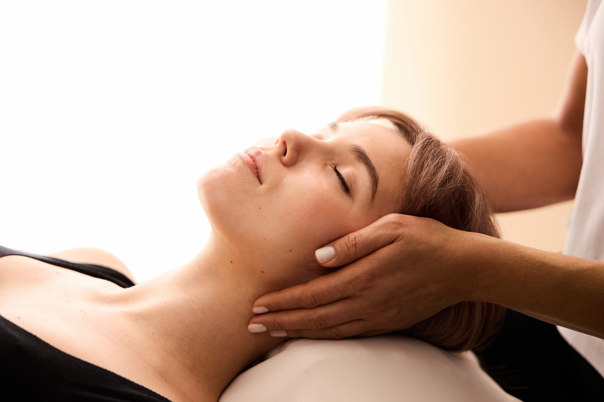 Frau erhält entspannende Nackenmassage in moderner Praxis – Nackenschmerzen, Physiotherapie und Wellness.